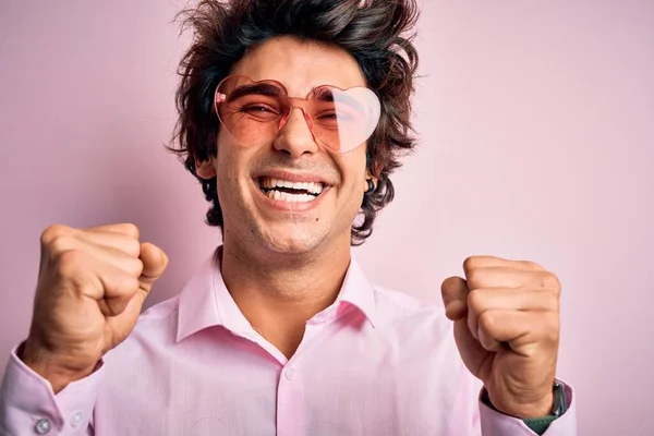Mladý Pohledný Muž Brýlích Srdcem Nad Izolovaným Růžovým Pozadím Slaví — Stock fotografie
