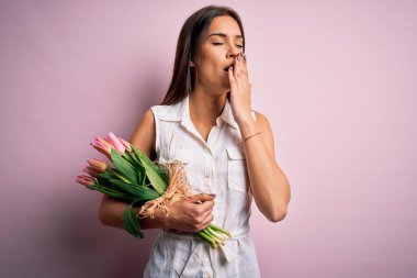 Genç, güzel, esmer bir kadın pembe arka planda bir buket lale tutuyor. Elle ağzını kapatmaktan sıkılmış. Huzursuz ve uykulu..