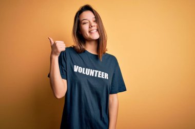 Genç ve güzel esmer kız gönüllü olarak tişört giyip gönüllü olarak mesaj yolluyor. Arkayı işaret ediyor.