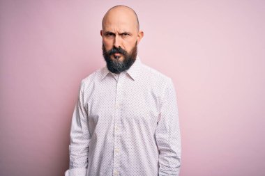 Sakallı, zarif tişörtlü yakışıklı, pembe arka plan kuşkucu ve gergin, sorun yüzünden suratını asan bir adam. Negatif kişi.