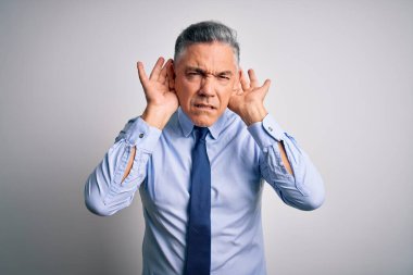 Orta yaşlı, yakışıklı, gri saçlı, şık gömlekli ve kravatlı bir iş adamı. İki elini de kulak hareketi yaparken duymaya çalışıyor. Dedikoduya meraklı. İşitme problemi, sağır