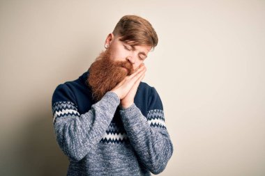 Sarışın, sakallı, kışın süveter giyen, soyutlanmış arka planda uyuyan, yorgun, hayal kuran, elleri ve gözleri kapalı gülümseyen yakışıklı bir İrlandalı..