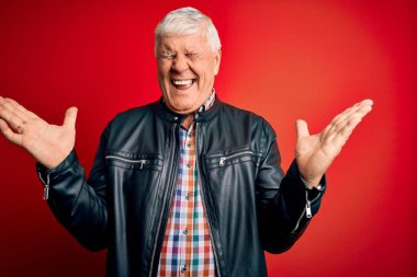 Kıdemli yakışıklı, beyaz gömlekli ve ceketli adam izole edilmiş kırmızı arka planda çılgın ve çılgın bir başarıyı kutluyor kolları havada ve gözleri kapalı heyecanla bağırıyor. Kazanan konsept