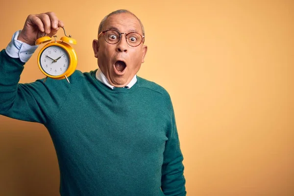 Senior Handsome Man Holding Alarm Clock Standing Isolated Yellow Background — Stock Photo, Image