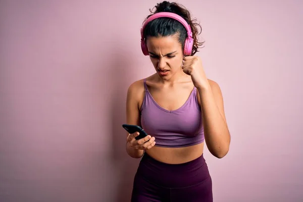 Sportowiec Kręconymi Włosami Uprawia Sport Słuchając Muzyki Pomocą Smartfona Słuchawek — Zdjęcie stockowe