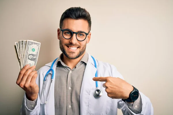 Jovem Médico Homem Segurando Monte Notas Dólar Sobre Fundo Isolado — Fotografia de Stock