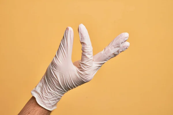 Mano Joven Caucásico Con Guante Médico Sobre Fondo Amarillo Aislado — Foto de Stock