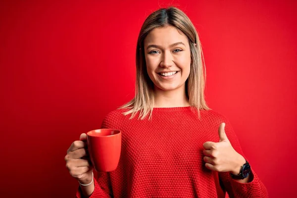 Jonge Mooie Vrouw Drinken Kopje Koffie Staan Geïsoleerde Rode Achtergrond — Stockfoto