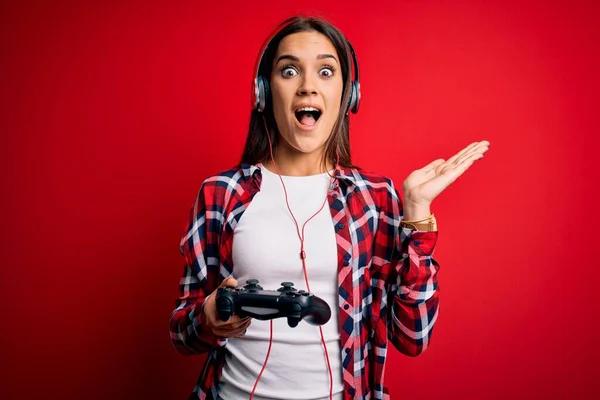 Ung Vakker Brunette Spillkvinne Som Spiller Dataspill Med Joystick Hodetelefoner – stockfoto