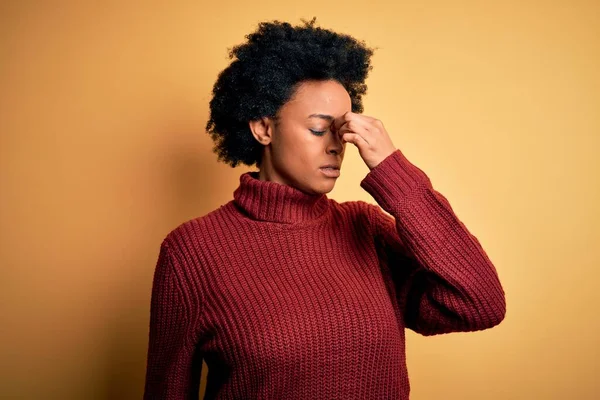 カジュアルなタートルネックセーターを着て巻き毛を持つ若い美しいアフリカ系アメリカ人アフロ女性は 鼻や目をこすり疲れや頭痛を感じて疲れている ストレスとフラストレーションの概念 — ストック写真