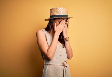 Genç, güzel, esmer kadın tatilde. Günlük elbiseler ve şapkalar giyiyor. Üzücü bir ifade takınıyor. Depresyon kavramı.