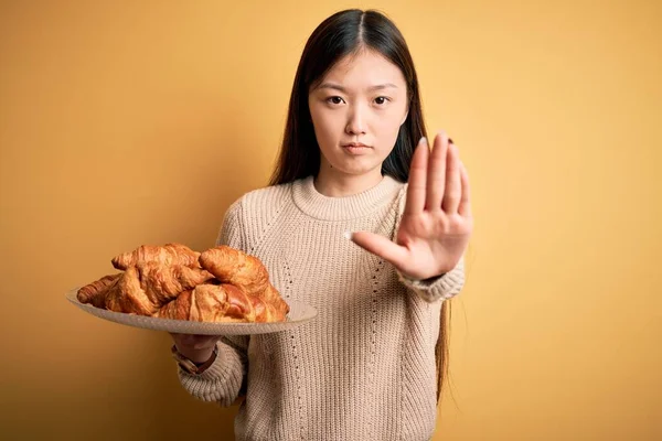Jovem Asiático Mulher Segurando Francês Pastelaria Croissant Sobre Amarelo Isolado — Fotografia de Stock