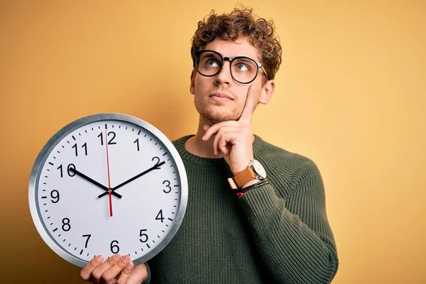 Young Blond Man Curly Hair Wearing Glasses Holding Big Clock — Stock Photo, Image