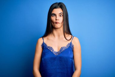Zarif ve rahat mavi iç çamaşırı giyen genç, güzel esmer kadın dudaklarıyla balık suratı yapıyor, çılgınca ve komik bir jest. Komik ifade.