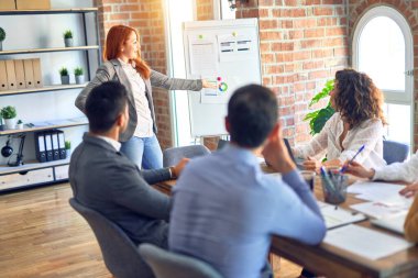 Group of business workers working together in a meeting. One of them making presentation to colleagues at the office