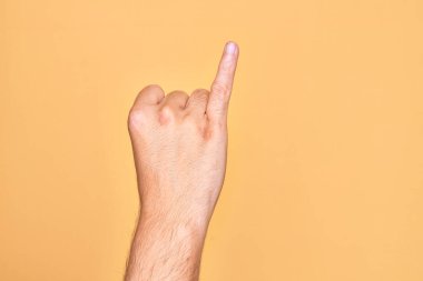Kafkasyalı bir gencin parmağı, izole edilmiş sarı arka planda serçe parmağı, bir numaralı söz sözü olarak gösteriyor.