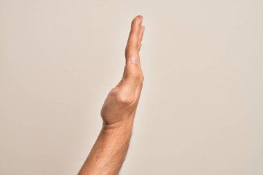 Beyaz arka planda parmaklarını gösteren beyaz tenli bir adamın eli uzatılmış el hareketlerini gösteriyor.