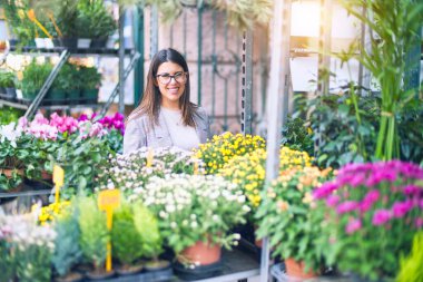 Mutlu ve kendinden emin gülümseyen genç ve güzel bir kadın. Çiçekçiye gülümsüyor.
