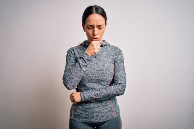 İzole edilmiş arka planda spor kıyafetleri giyen genç sarışın kadın kendini iyi hissetmiyor ve soğuk algınlığı veya bronşitin belirtisi olarak öksürüyor. Sağlık hizmeti kavramı.