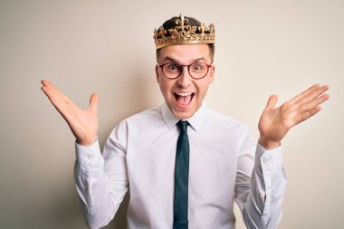 Kafkasyalı yakışıklı iş adamı, izole edilmiş arka planda altın taç takıyor. Çılgınlığı kutluyor ve başarıyı kollarını kaldırıp heyecanla haykırarak haykırıyor. Kazanan konsept