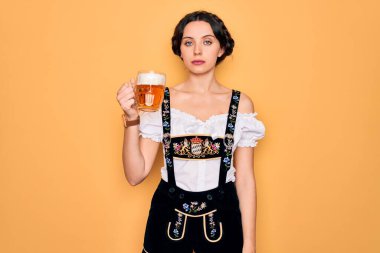 Mavi gözlü güzel Alman kadın geleneksel Ekim Festivali elbisesi giyiyor. Kendine güvenen bir ifadeyle bir kavanoz bira içiyor.