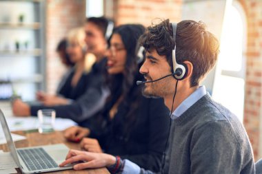 Group of call center workers smiling happy and confident. Working together with smile on face using headset at the office.