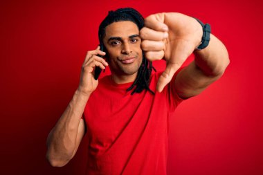 Afrika kökenli Afro Amerikalı genç bir adam. Rasta saçlı, akıllı telefonda kızgın yüzle konuşuyor. Negatif işaretler, reddedilme kavramından hoşlanmadığını gösteriyor.