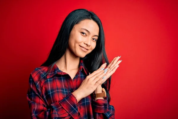 年轻美丽的中国女人 穿着休闲装 越过孤立的红色背景 拍手喝彩 欢快快乐 自豪地携手共进 — 图库照片