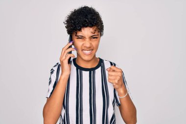 Genç ve güzel afro-amerikan kadın akıllı telefonda konuşuyor sinirlenmiş ve sinirlenmiş bağırıyor, çıldırmış ve el kaldırarak bağırıyor, öfke kavramı