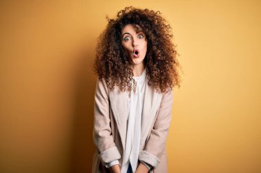 Kıvırcık saçlı ve piercingli genç ve güzel bir kadın. Günlük tişört ve diyabet giyiyor. Şok olmuş ve korkmuş..