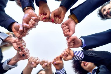 Bir grup işçi ofiste yumruk tokuşturuyor.