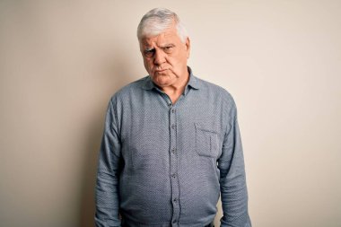 Üst düzey yakışıklı beyaz gömlekli adam izole edilmiş beyaz arka plan şüphecisi ve sinirli, sorun yüzünden surat asıyor. Negatif kişi.