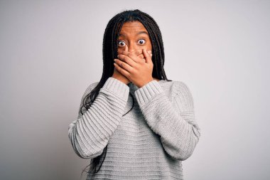 Gri izole arka planda rahat ve rahat duran genç Afrikalı Amerikalı kadın yanlışlıkla ağızlarını kapatarak şok geçirdi. Gizli konsept.