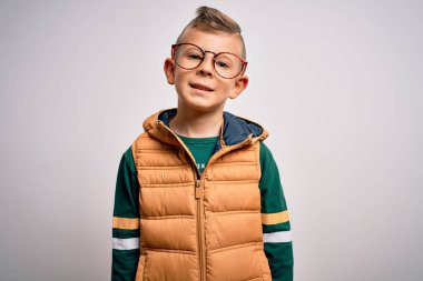 Mavi gözlü küçük beyaz çocuk kışlık ceket giyiyor ve yüzünde mutlu ve havalı bir gülümseme olan gözlük takıyor. Şanslı kişi..