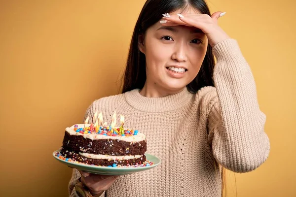 Junge Asiatin Mit Geburtstagstorte Und Brennenden Kerzen Vor Gelbem Hintergrund — Stockfoto