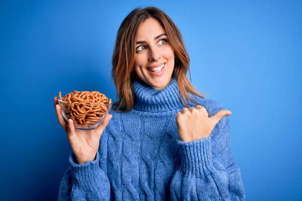 Young Beautiful Brunette Woman Holding Bowl German Baked Pretzels Blue — Stock Photo, Image