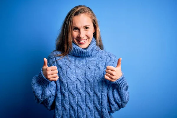Młoda Piękna Blondynka Ubrana Luźny Sweter Golfem Niebieskim Tle Znak — Zdjęcie stockowe