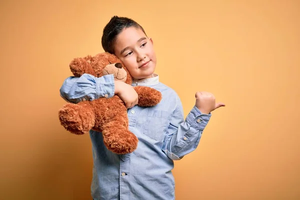 Küçük Çocuk Oyuncak Ayıya Sarılıp Sarı Arka Planda Duran Oyuncak — Stok fotoğraf