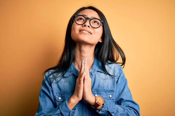 Junge Schöne Chinesin Lässigem Jeanshemd Vor Isoliertem Gelben Hintergrund Bettelt — Stockfoto