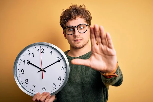 Young Blond Man Curly Hair Wearing Glasses Holding Big Clock — Stock Photo, Image