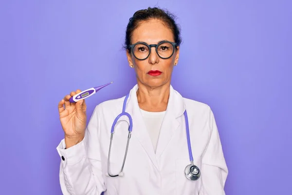 中年シニアプロの医師女性を保持しています医療温度計で自信を持って式上のスマート顔真剣に考えて — ストック写真