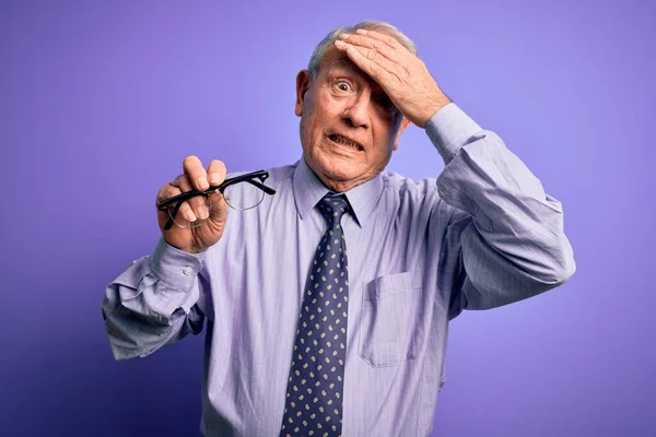 Hombre Pelo Gris Mayor Sosteniendo Gafas Corrección Sobre Fondo Púrpura — Foto de Stock