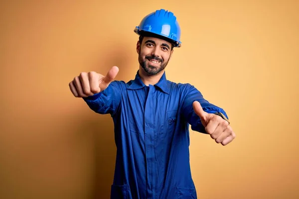 Mechaniker Mit Bart Blauer Uniform Und Schutzhelm Vor Gelbem Hintergrund — Stockfoto