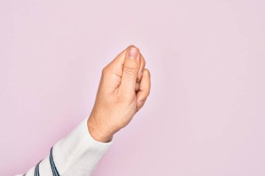 İzole edilmiş pembe arka planda parmaklarını gösteren beyaz bir gencin eli parmak, iş ve reklamla boş bir alan tutuyor.