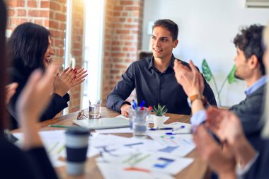 Group of business workers smiling happy and confident. Working together with smile on face applauding one of them at the office