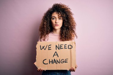 Kıvırcık saçlı ve piercingli genç ve güzel bir kadın. Değişim istiyor. Yüzünde kendine güvenen bir ifade var.