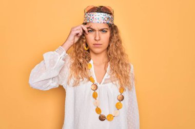 Genç, sarışın, mavi gözlü, güneş gözlüklü ve aksesuarlı, alnındaki sivilceden mutsuz olan, siyah başlıklı, çirkin enfeksiyonlu sarışın bir kadın. Sivilce ve deri problemi