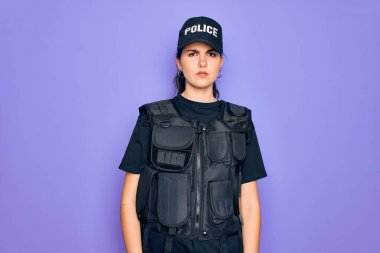 Mor arka planda kurşun geçirmez yelek giyen genç bir kadın. Uykulu ve yorgun görünüyor. Yorgunluktan ve akşamdan kalmalıktan yorgun..