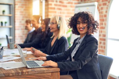 Group of call center workers smiling happy and confident. Working together with smile on face using headset at the office.
