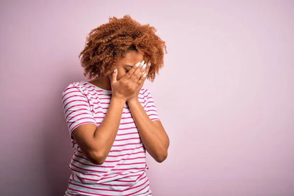 泣きながら手で顔を覆う悲しい表情のカジュアルなストライプのTシャツを着て巻き毛を持つ若い美しいアフリカ系アメリカ人アフロ女性 うつ病の概念 — ストック写真